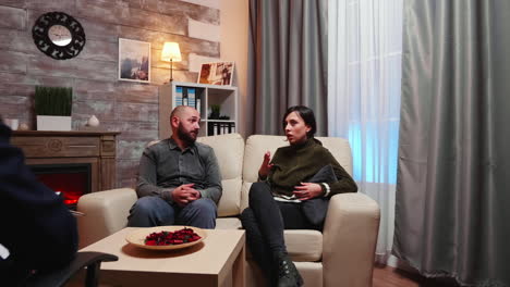 vista trasera del psicoterapeuta aconsejando al joven marido y esposa