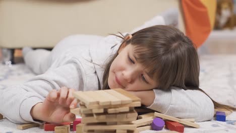 una niña linda está jugando en el suelo de su habitación.