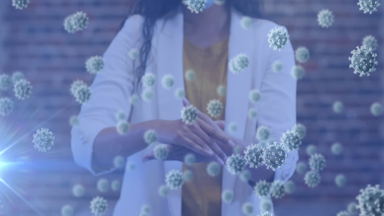 animación de células de covid-19 flotando sobre la sección media de una mujer desinfectando las manos usando una máscara facial