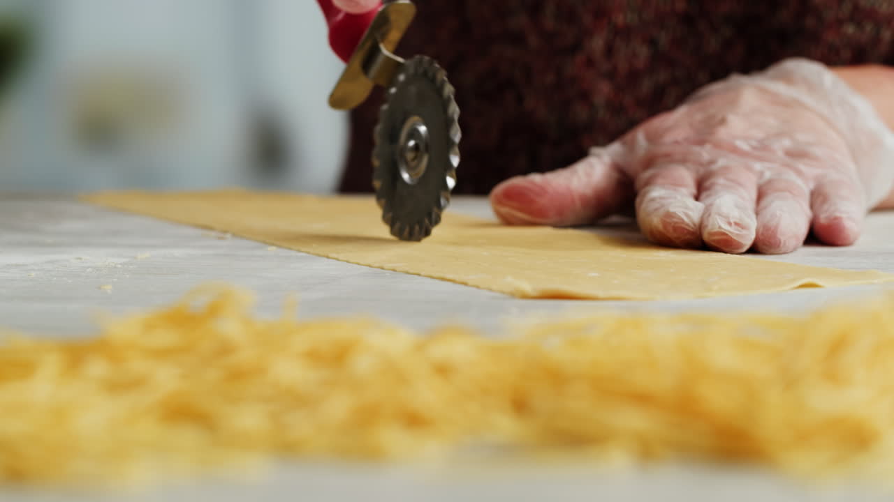 Close-Up of Hands Cutting Fresh Homemade Pasta Dough