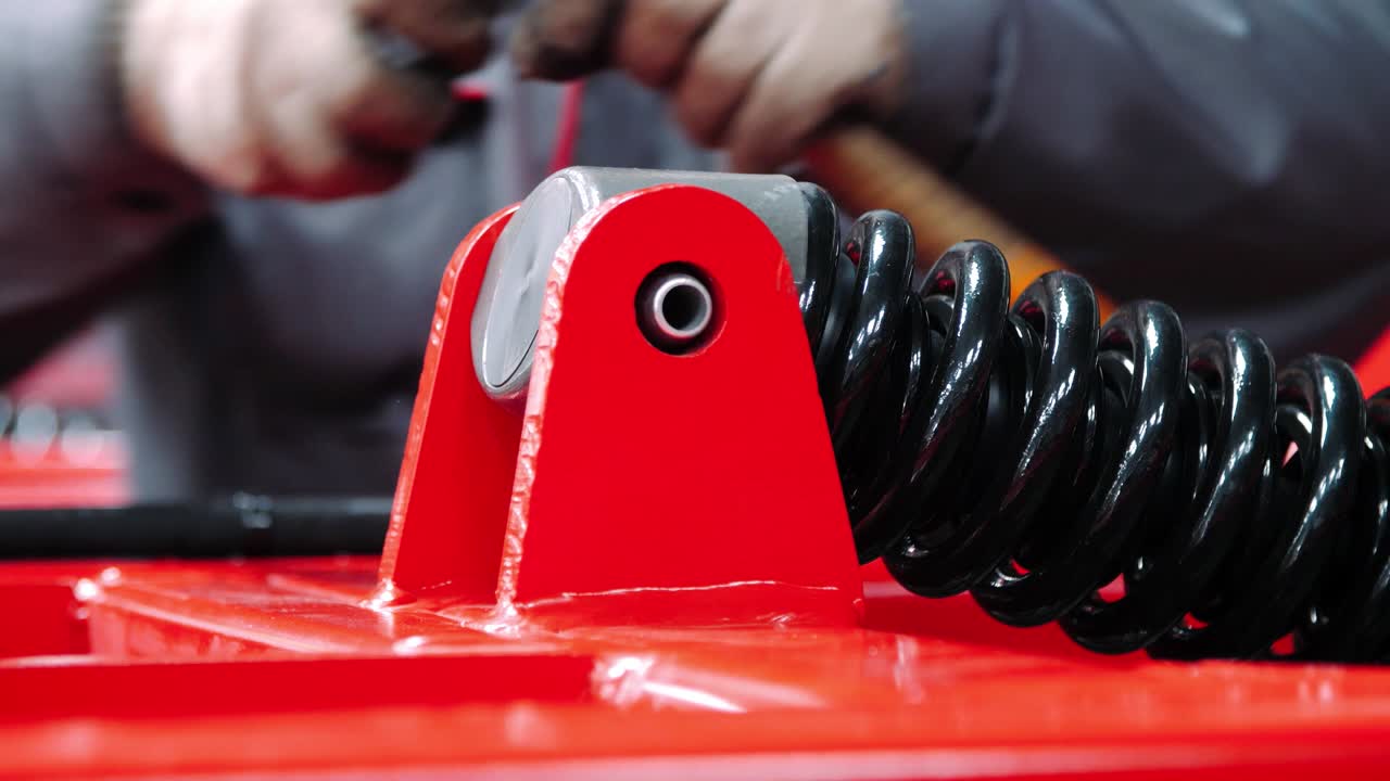 механик, работающий в сборочной мастерской тяжелых единиц. крепление амортизатора