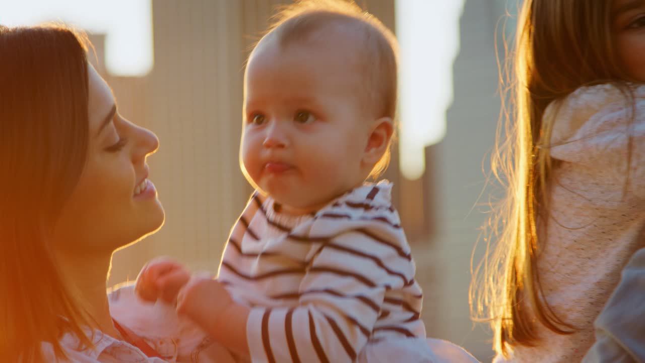 어머니는 맨해튼에 서서 해가 지는 동안 어린 딸을 안고 있습니다.