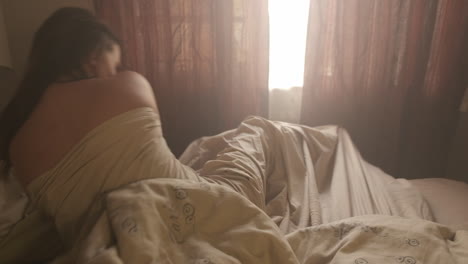 medium shot of woman waking up and sitting upright