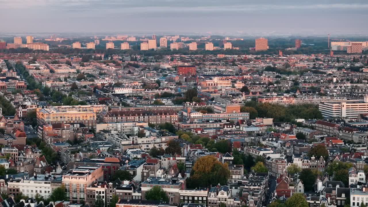 Aerial dolly left over Amsterdam rooftops glowing in the sunrise
