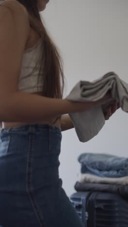 mujer plegando ropa