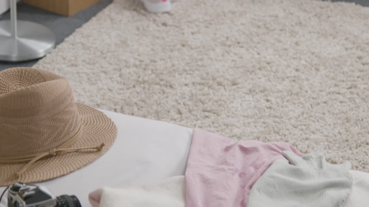 여름 휴가를 위해 집에서 침대 위에 열린 수하물의 클로즈업