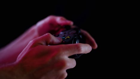 Spielen-Von-Videospielen-In-Einem-Abgedunkelten-Raum-Mit-Schwarzem-Hintergrund,-Nahaufnahme-Auf-Langsam-Abspielenden-Controller-Tasten-Für-E-Sport