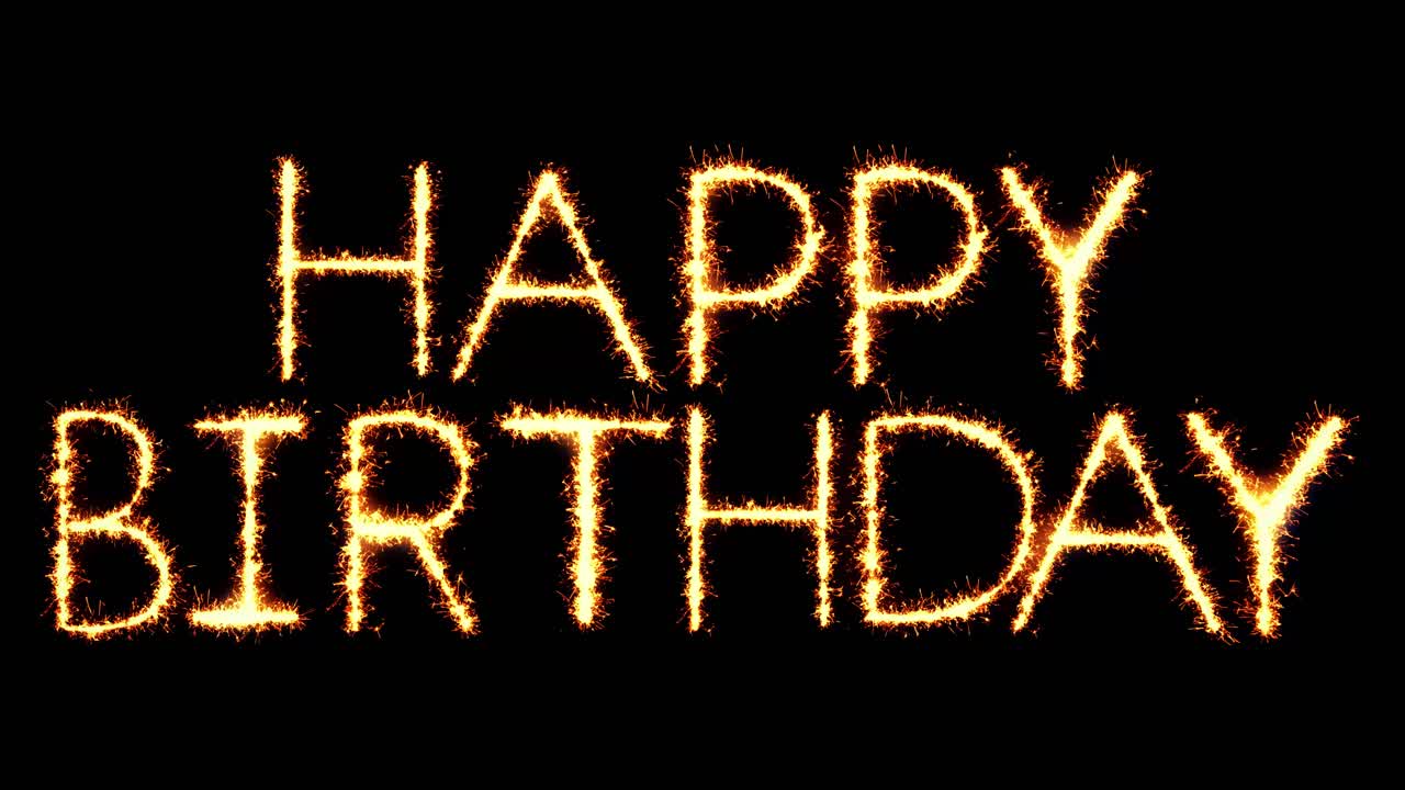 Happy birthday text sparkler writing with glitter sparks particles firework on black 4k loop