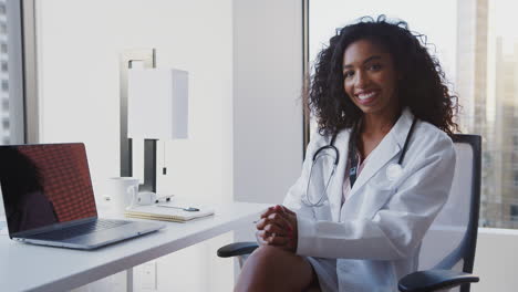 Portrait-Of-Smiling-Female-Doctor-Wearing-White-Coat-With-Stethoscope-In-Hospital-Office