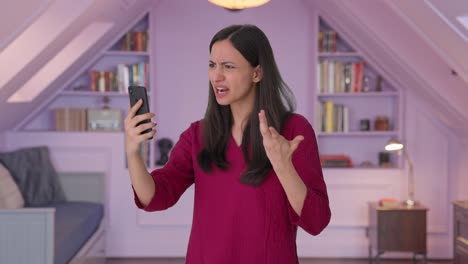 chica india enojada gritando a alguien en una videollamada