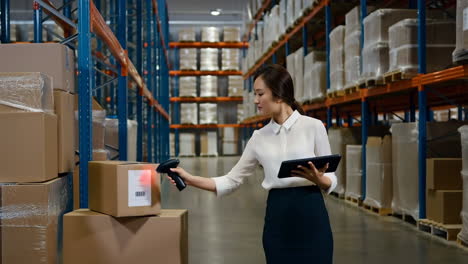woman managing inventory and scanning packages in a warehouse