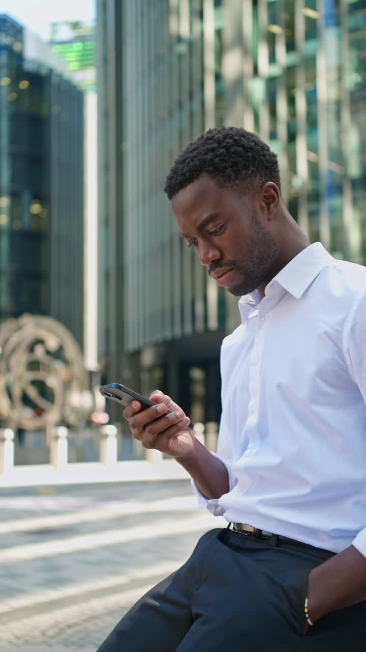 Vertical Video Of Young Businessman In Shirt Sleeves Using Mobile Phone Standing Outside Offices In The Financial District Of The City Of London UK Shot In Real Time 1