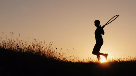 entrenando al aire libre - una silueta de una mujer saltando sobre una cuerda al atardecer