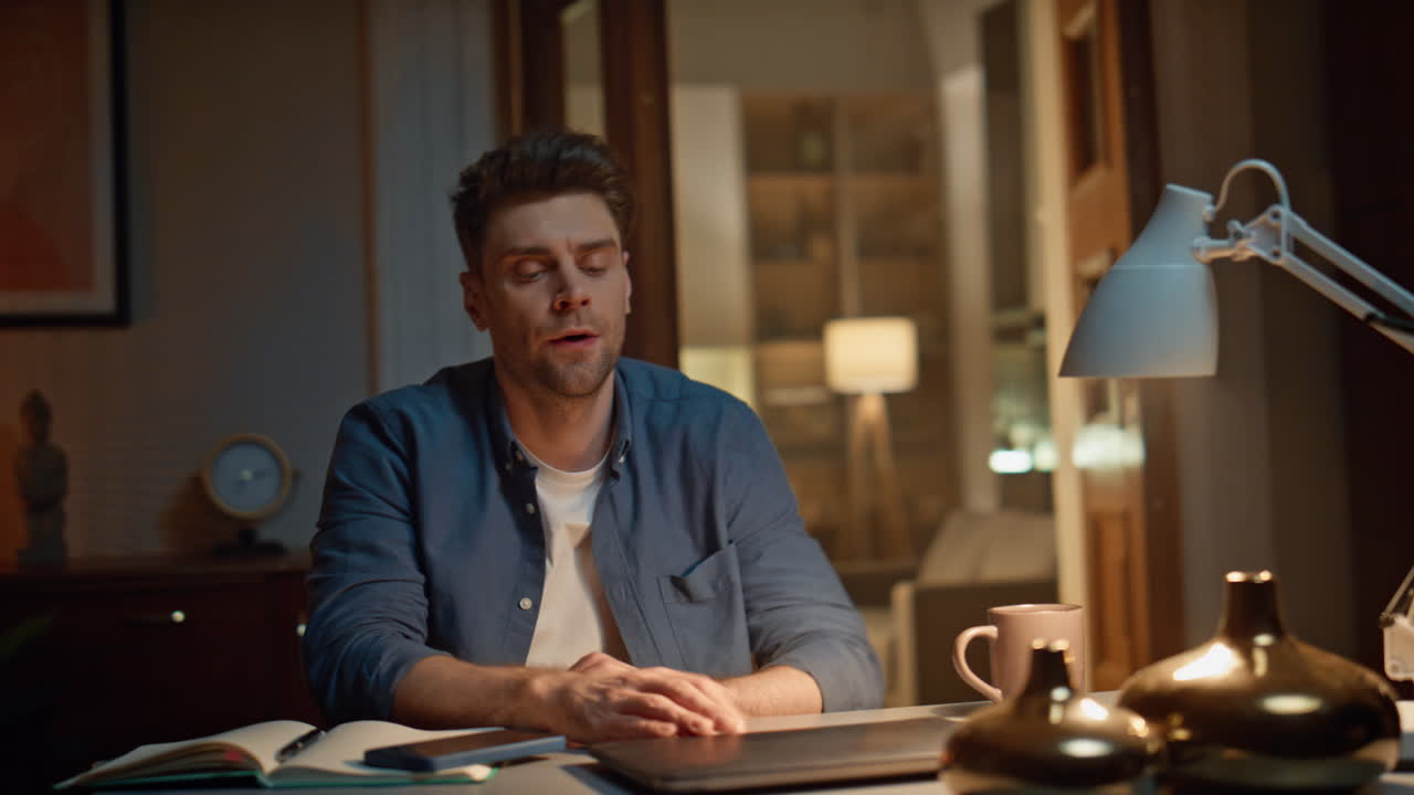 Tired man working late at home closeup. Overworked guy closed laptop ending work