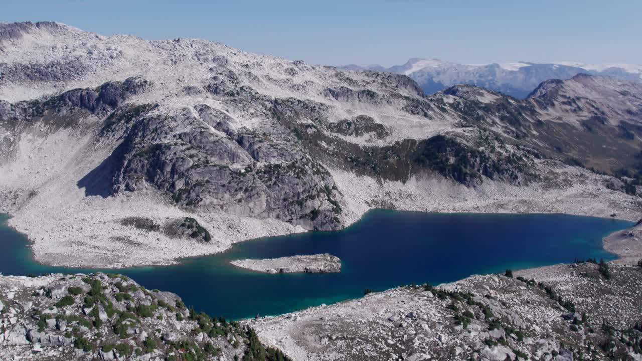 An alpine lake in the mountains of British Columbia during the summer. The beautiful water colours and mountain peaks as far as the eye can see really make the shot!