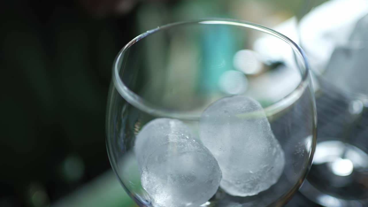 close up of ice cubes inside clear glass tumbler, bar scene