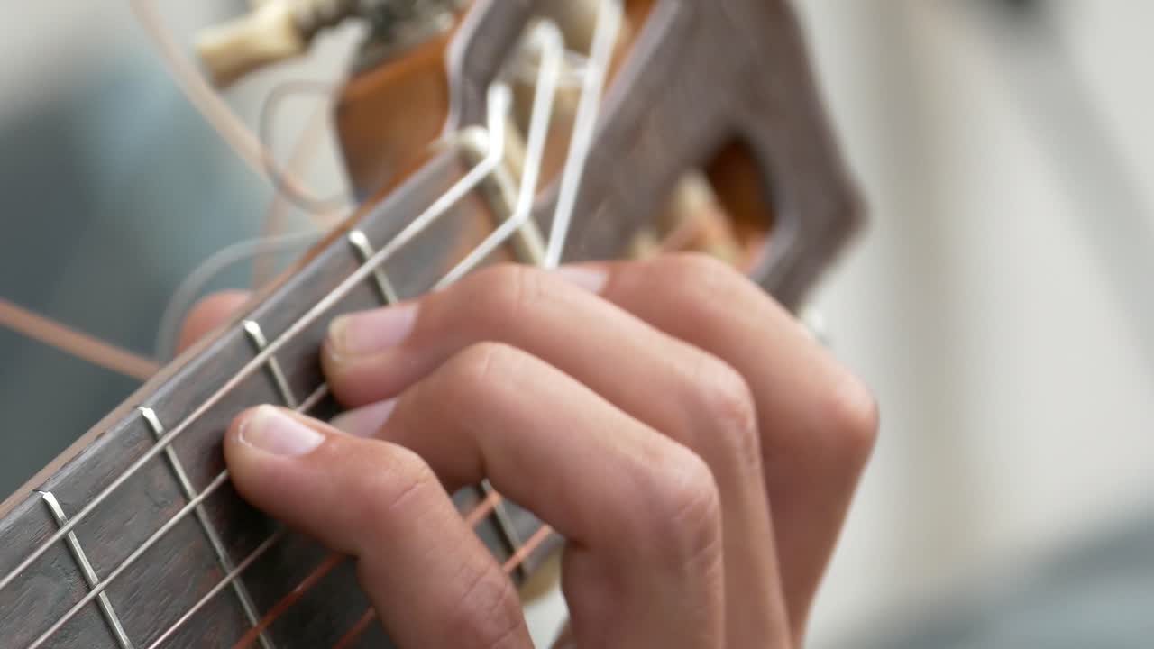 Young hands playing chords and a small solo on a vintage classic guitar with nylon chords