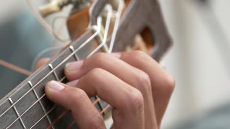 Manos-Jóvenes-Tocando-Acordes-Y-Un-Pequeño-Solo-En-Una-Guitarra-Clásica-Vintage-Con-Cuerdas-De-Nailon