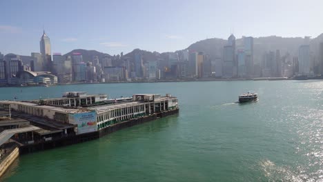 star ferry terminal at victoria harbour with the view of hong kong modern skyline buildings under gray, hazy sky due to air pollution, hong kong, china