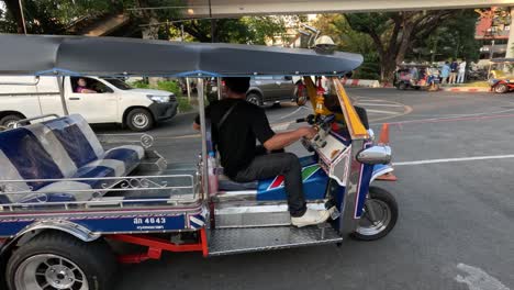 el conductor sube a bordo y prepara el tuk tuk para la salida