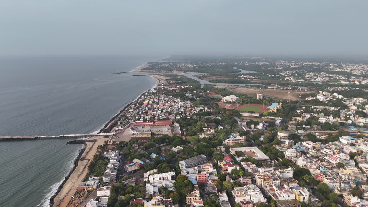 Sorvolo di drone su un complesso di edifici bianchi in stile coloniale con corridoi ad arco.