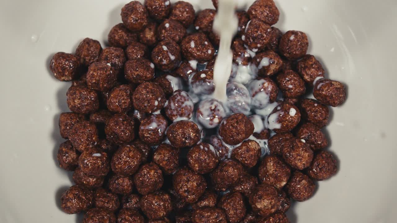 Milk is poured into breakfast cereals chocolate corn balls