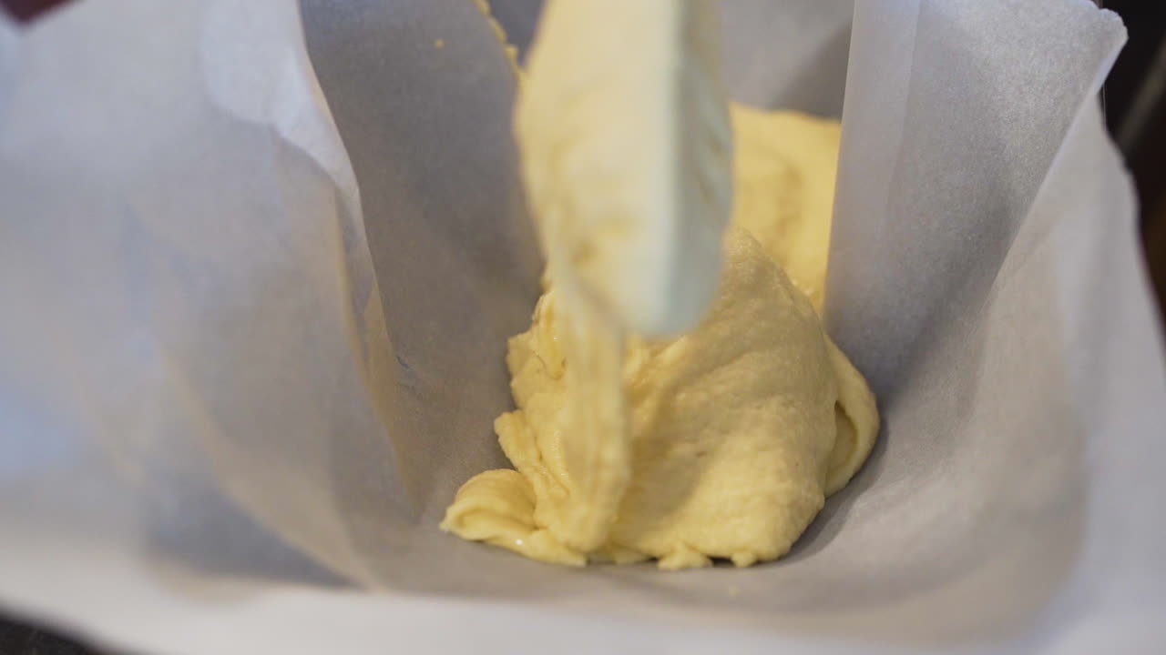 Pastry chef pouring cake batter into a baking tray in slow motion