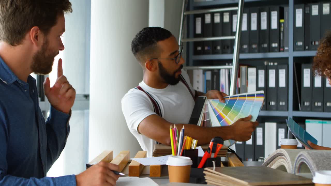 Business colleagues discussing over color swatch at desk 4k