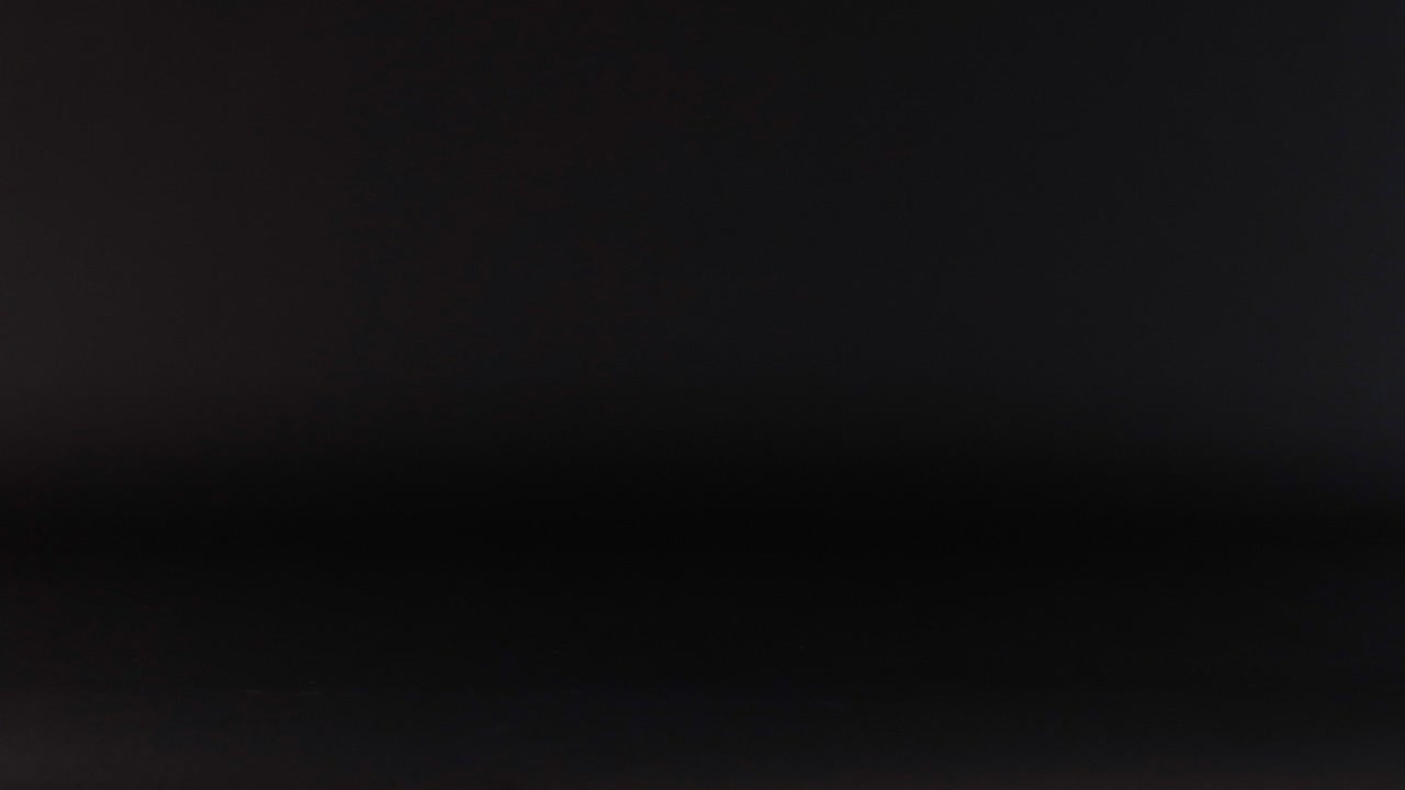 una pelota rosa rebota contra un fondo oscuro