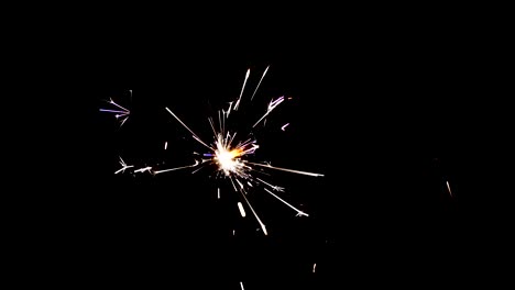 sparkler fireworks with shower of sparks flying against a black background