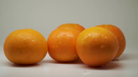 five sweet oranges at the top of the table with white background - close up shot