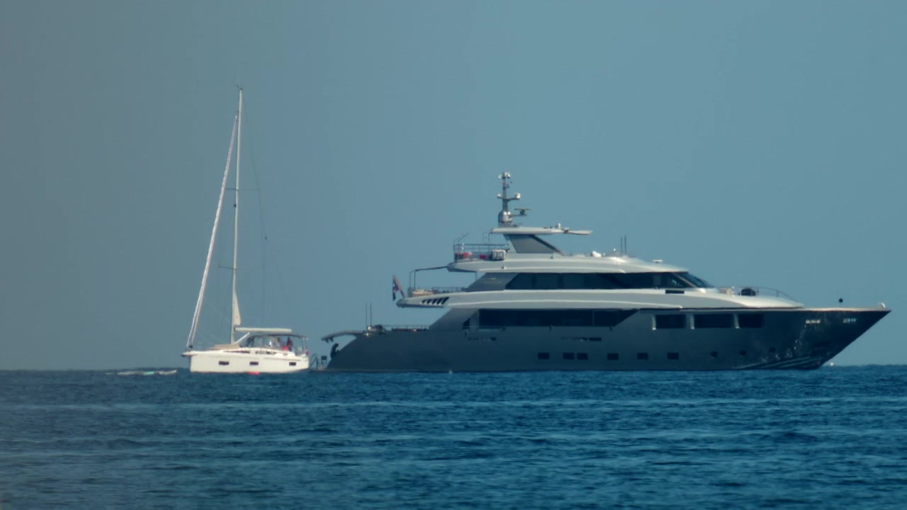 Grande superyacht moderno che naviga sull'oceano blu con cielo sereno, rappresentando ricchezza, svago e viaggi di lusso.