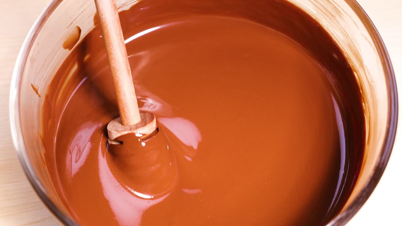 나무 막대기 가 그 에 녹은 초콜릿 을 고 있다