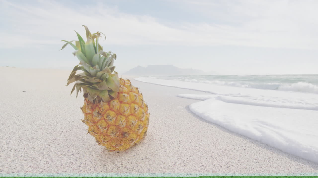 Pineapple resting on sandy beach with ocean waves under cloudy sky