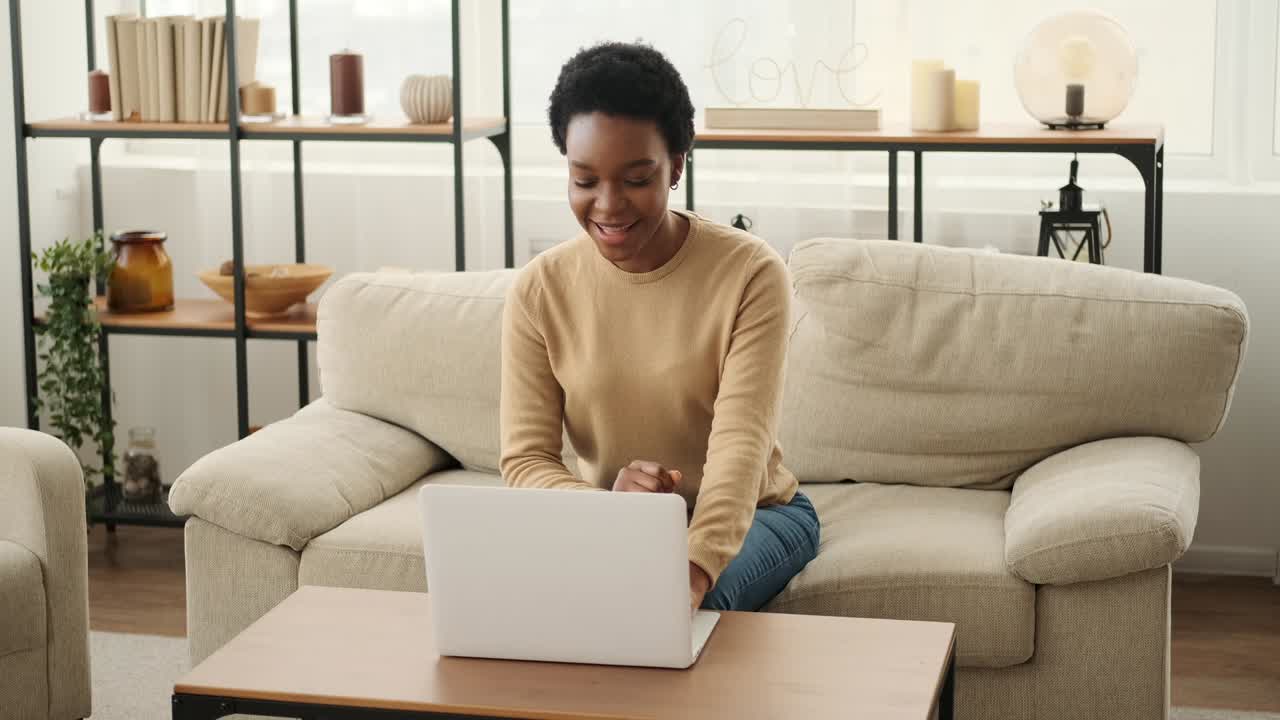 Excited woman using laptop and celebrating success holding a bundle of cash dollars
