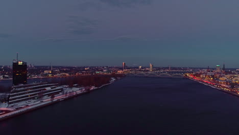 aerial wide shot showing daugava river in riga city after sunset - latvia,europe