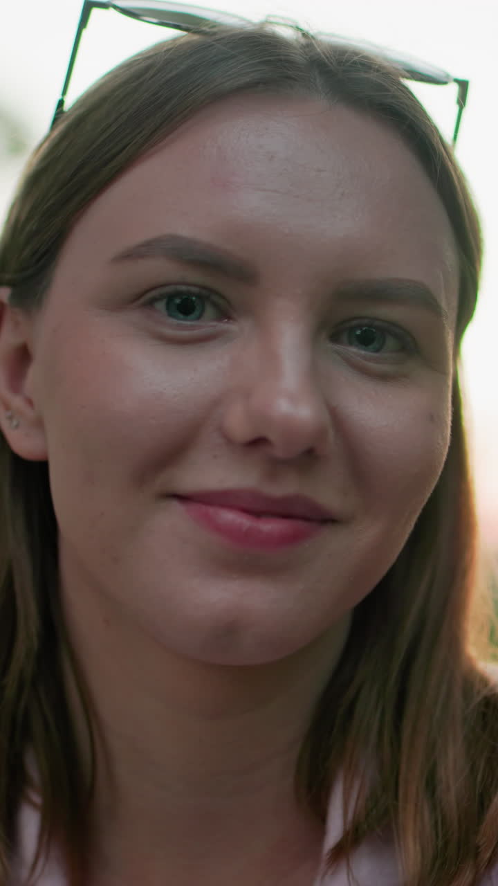 primer plano de una mujer con una cálida sonrisa, rodeada de árboles verdes y una suave iluminación exterior, creando una atmósfera serena en un entorno natural, perfecto para el estilo de vida