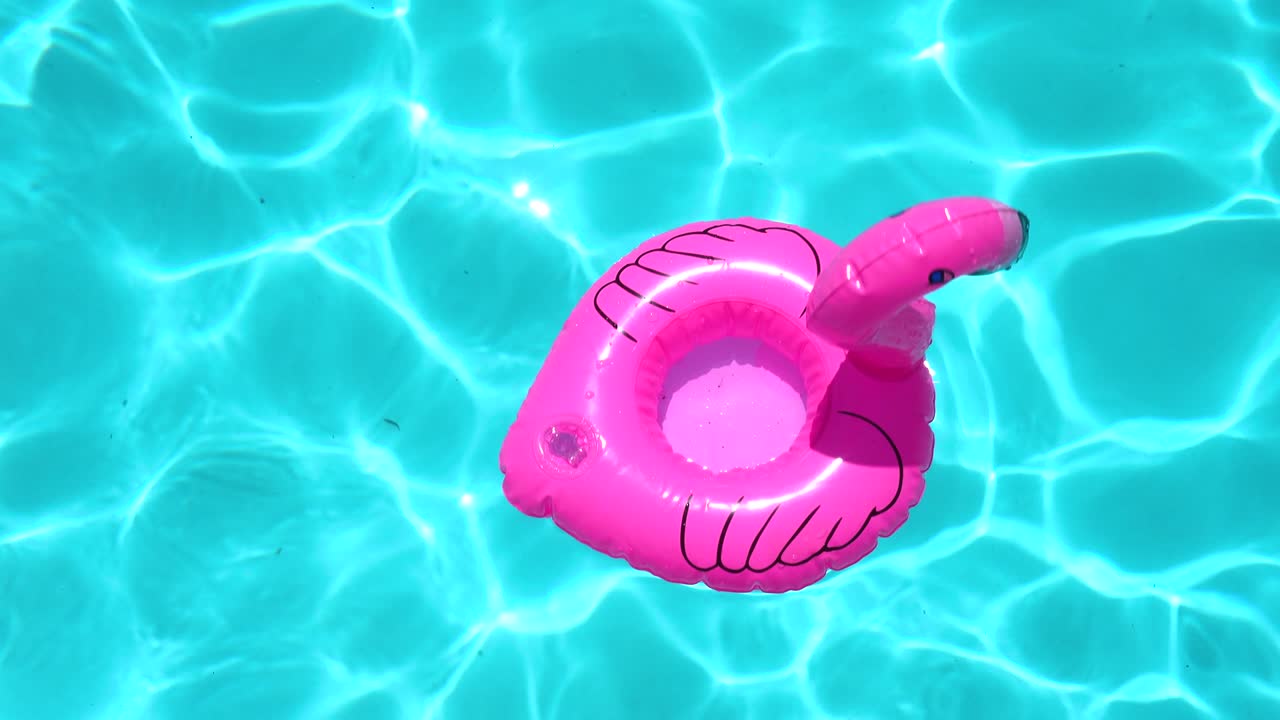 anillo inflable en forma de flamenco flotando en la piscina durante un día soleado