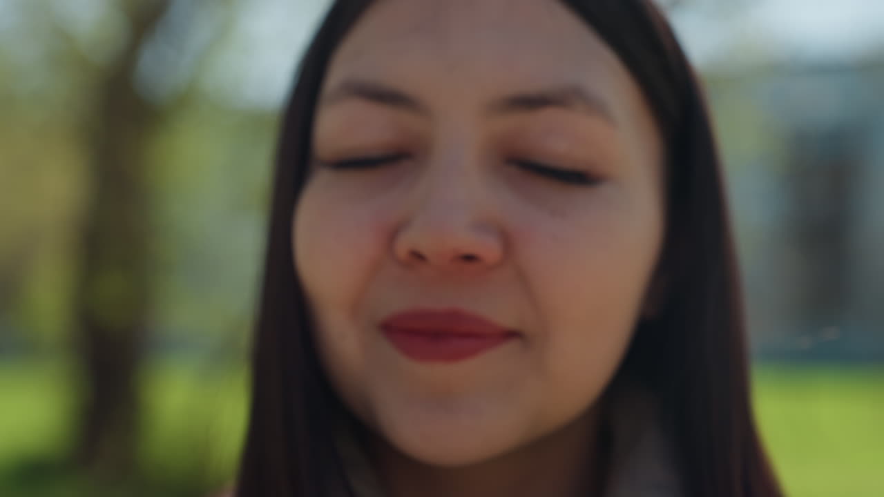 Mujer en un parque ofrece alegre ramo de flores; mujer alegre muestra brillante arreglo de dientes de león en el exterior; mujer presenta alegremente un ramo de dientes de león amarillos en un parque soleado