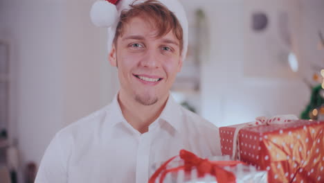 hombre guapo mirando regalos de navidad en casa