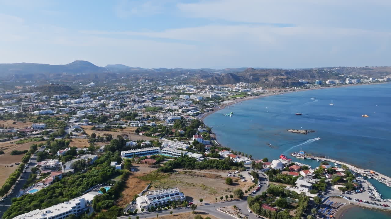 revelación aérea de la inclinación del puerto de faliraki, la playa y el pueblo, día soleado en rodas