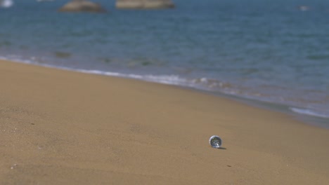 wave washing bottle up a beach