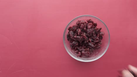 hand picking dried cranberries from a bowl