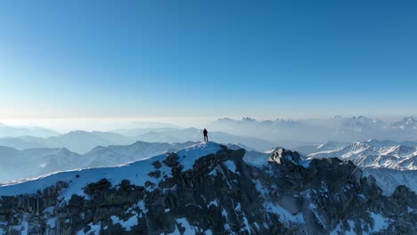 Mountaineer-with-ice-axe-standing-on-a-mountain-ridge-in-the-Italian-Alps