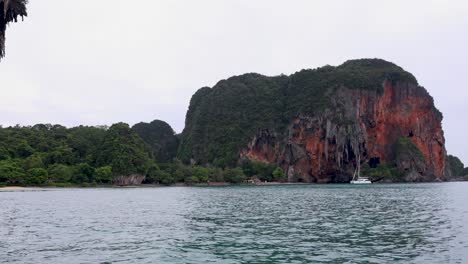 long-tail boat passing stunning krabi rock formations