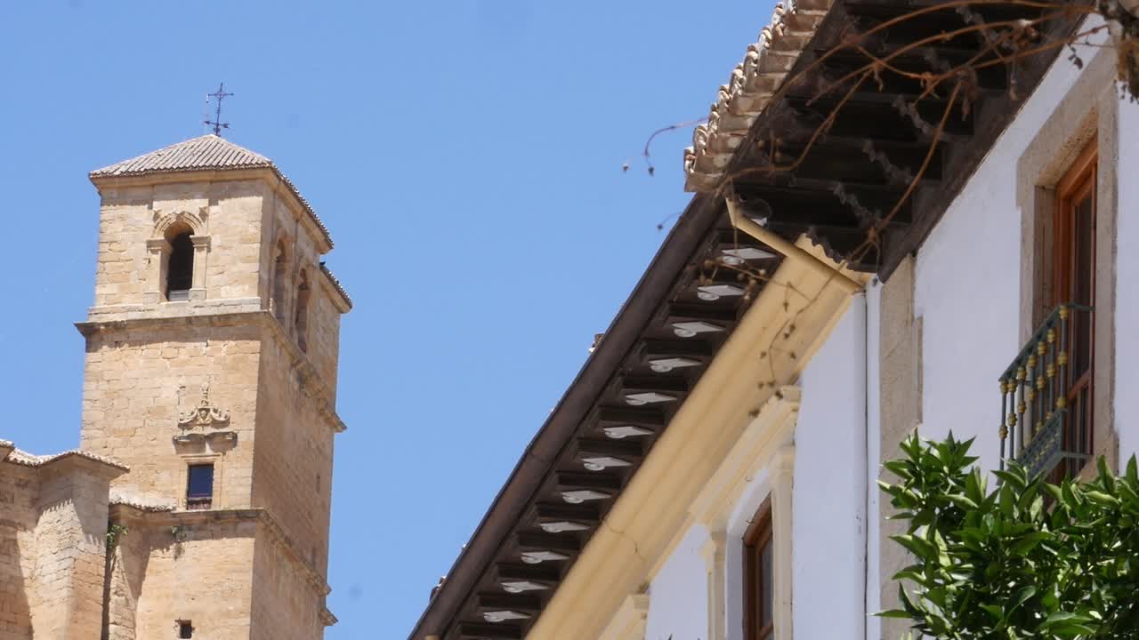 Stone church tower and traditional balcony in Montefrío, Granada