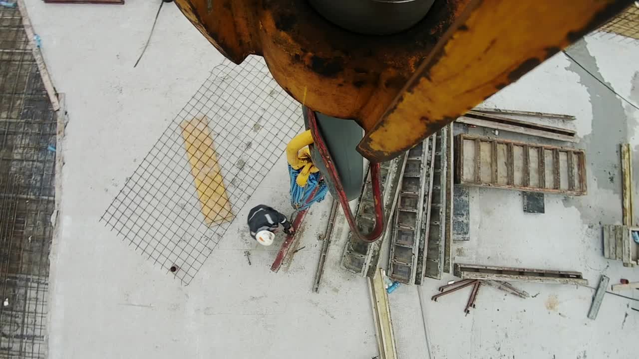 A construction worker is installing an element onto the crane hook