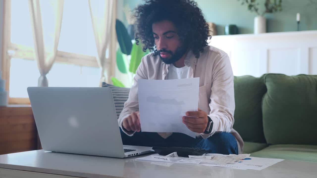 Young arabian man uses laptop to fill out financial or tax returns