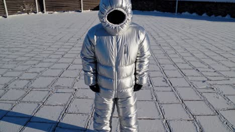 silver puffer jacket and snowsuit on a snowy day