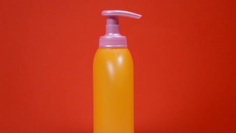 an orange soap dispenser plastic bottle on a rotating surface